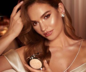 actress lily james holding the new charlotte tilbury hollywood glow glide face architect highlighter